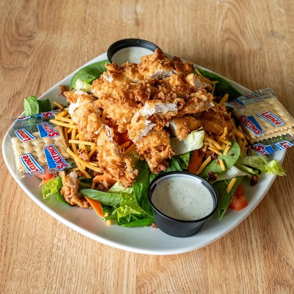 Crispy fried chicken salad with cheese, bacon, lettuce, tomato, and two packets of Saltines.